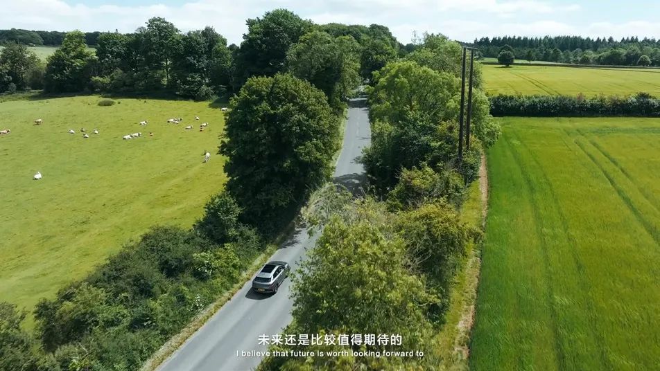 Vehicle travelling along a rural road in an aerial film frame.